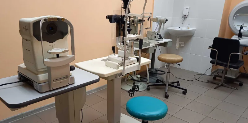 Gabinet okulistyczny z aparaturą diagnostyczną i fotelem do badań.