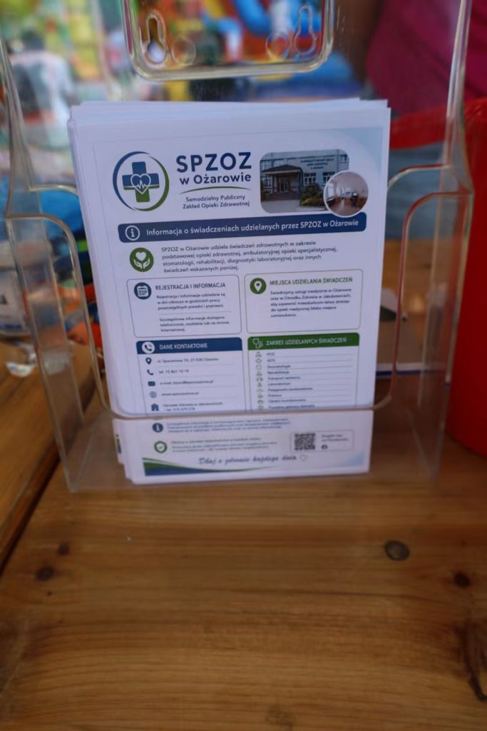 Ulotki informacyjne o świadczeniach SPZOZ w Ożarowie w stojaku na stole.